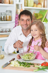 Obraz na płótnie Canvas father and daughter preparing salad 