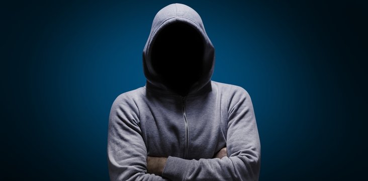 Composite image of hacker standing with arms crossed 