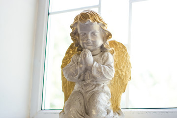Statue of an angel in a church on a windowsill.