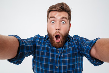 Close up picture of Shocked bearded man in checkered shirt