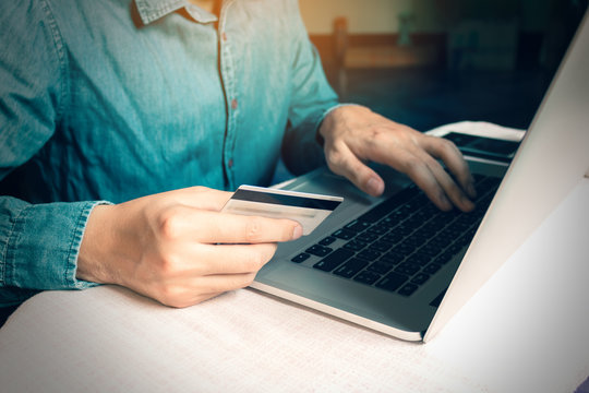 Man pressing keyboard and holding credit card with shopping online concept.