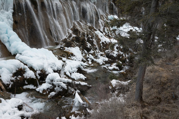 Fototapeta na wymiar Waterfall of cold water on a rock