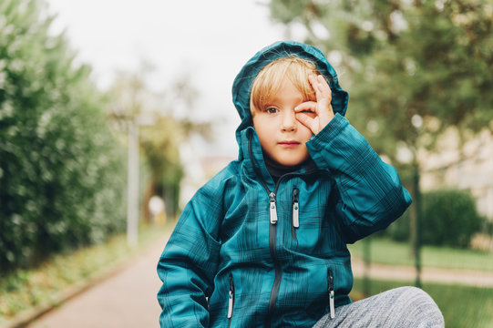 Outdoor portrait of cute little boy pretending taking photos with his hand, child wearing warm waterproof blue jacket