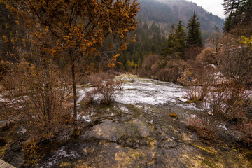 Fototapeta na wymiar Autumn waterfall on a mountainside in the forest