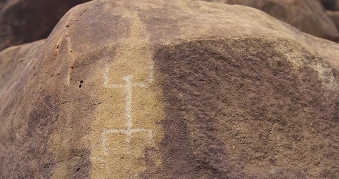 Prehistoric petroglyphs drawing on rock. Historical script is engraved on stone. Art is on textured surface at Shipwreck beach on Lanai, Hawaii.