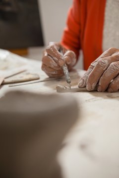 Mid section of woman shaping clay
