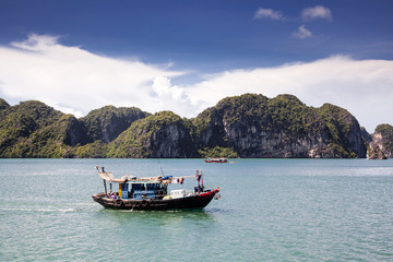 cruising among beautiful limestone rocks and secluded beaches in Ha Long bay, UNESCO world heritage site, Vietnam