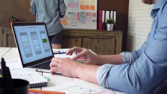 UX designer creating mobile app prototype on his laptop computer