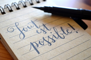 TOUT EST POSSIBLE écrit sur un cahier