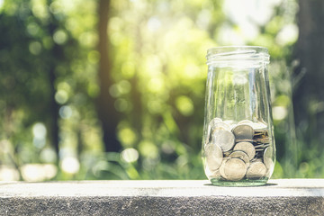 Concept of saving money by collecting coins in a glass jar. Money Thailand.