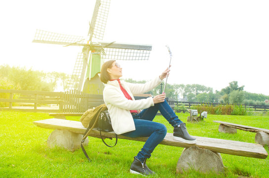 Asian woman taking photo with smartphone in Zaanse Schans, Netherlands