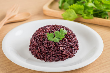 Black rice cooked on white plate