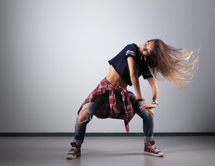 modern young beautiful dancer posing on a studio background