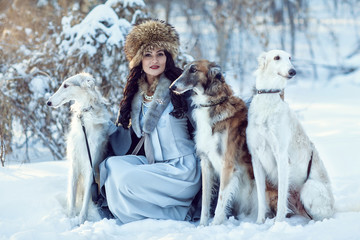 A girl with greyhounds on the snow