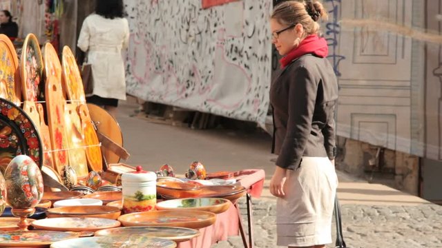 young woman in glasses buys plates