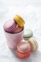 Colorful macarons on a white background. French sweets viewed from above on a white paper