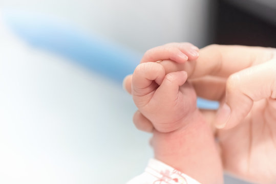 Newborn hand holding mother finger in hospital, Baby and Health care concept, Selective focus and White vignette