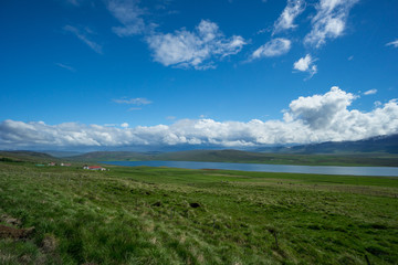 Fototapeta na wymiar Iceland - Blue lake betwen green fields and mountains