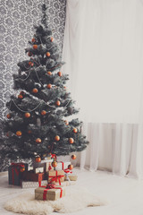 Christmas decorated tree in modern interior, holiday concept
