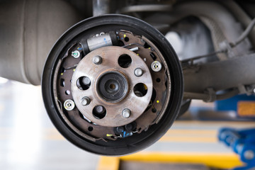 car suspension & bearing of wheel hub in auto service maintenance. Car lift up by hydraulic,...