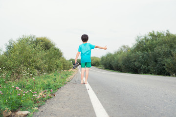 Obraz premium the boy walks barefoot along the road