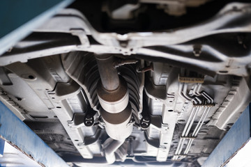 undercarriage of a car in garage. vehicle maintenance in auto repair service. automobile annual checkup.  fixing, checking concept