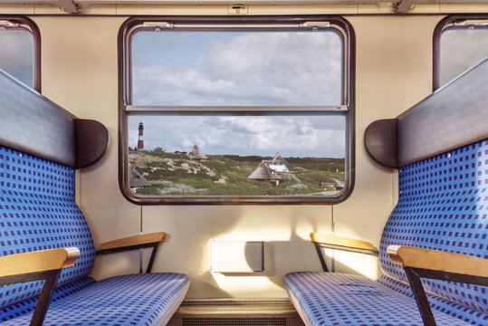 Fototapeta empty train compartment with view on quaint landscape through window