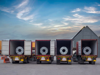 Steel coils in containers awaiting for unstuffing on turck at outdoor yard.