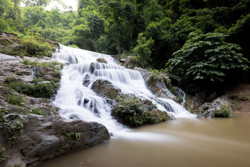 Fototapeta premium Smooth flow water from Mae Phun waterfalls in Laplae District, Uttaradit province of Thailand