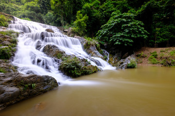 Fototapeta premium Smooth flow water from Mae Phun waterfalls in Laplae District, Uttaradit province of Thailand