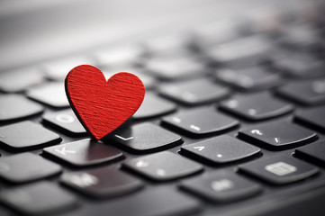 Small red heart on keyboard. Internet dating concept.