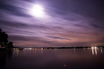 Moon with clouds over lake