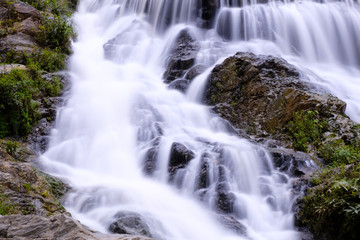 Fototapeta na wymiar Closeup smooth flow water from Mae Phun waterfalls in Laplae District, Uttaradit province of Thailand