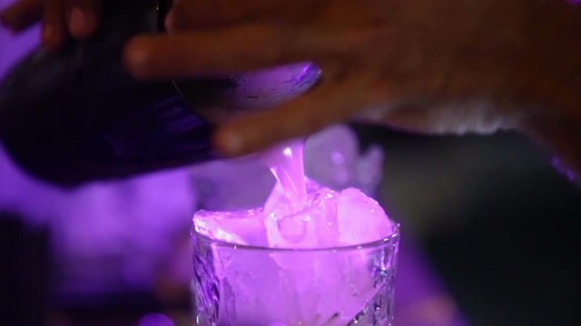 Barman sta preparando un cocktail con ghiaccio in discoteca al bar