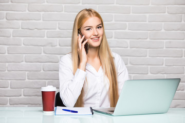 business concept businesswoman talking on the phone in office at table with laptop