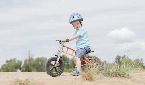 Toddler on a Strider Bike at a Dirt Track Wearing Helmet