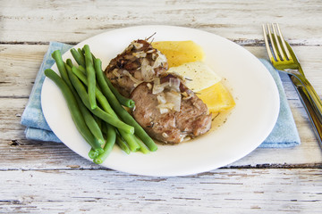 Pork tenderloin with potato chips and vegetable served on a plate