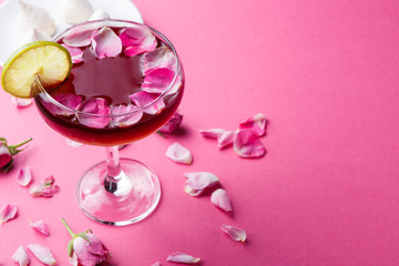 Rose cocktail in champagne glass on pink background