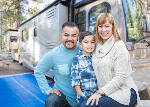 Happy Young Mixed Race Family In Front Of Their Beautiful RV At The Campground.