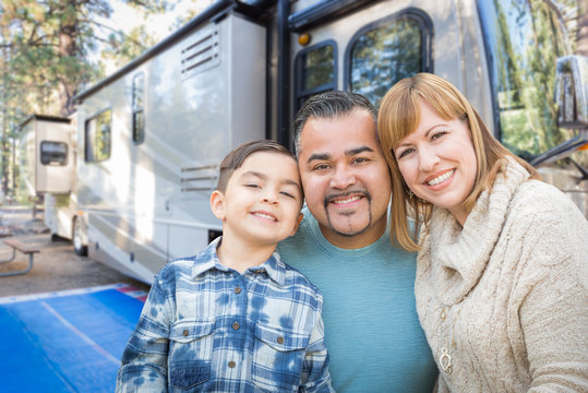 Happy Young Mixed Race Family In Front of Their Beautiful RV At The Campground.