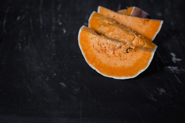 pieces of fresh raw pumpkin on a black background