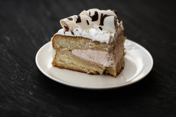 piece of cake in a white plate on a black background