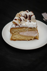 piece of cake in a white plate on a black background