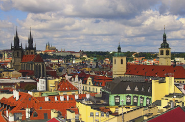 Fototapeta na wymiar Amazing view of the center of Prague from the Powder Tower. In the foreground there are towers of Church of Our Lady before Tyn. On the horizon is visible Prague Castle with St. Vitus Cathedral