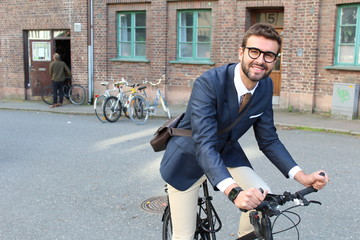 Stylish businessman riding a bicycle in the city