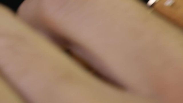 mani di un orologiaio che allacciano un cinturino in pelle di un orologio da polso