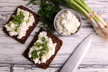 Cream Cheese on a slice of bread topped with fresh green onions or spring onions