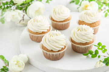 Obraz na płótnie Canvas delicious vanilla cupcakes with cream cheese frosting