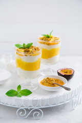 delicious mango,  passion fruit and cream cheese layered dessert on glasses