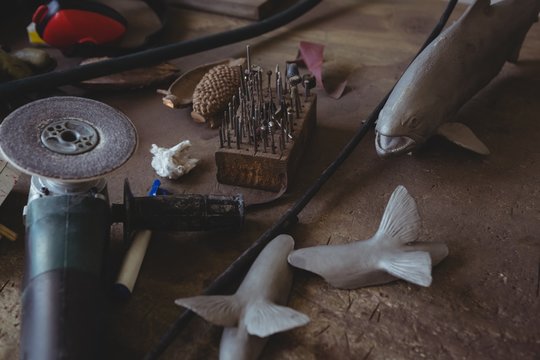 Metal fish and hand tool on worktop